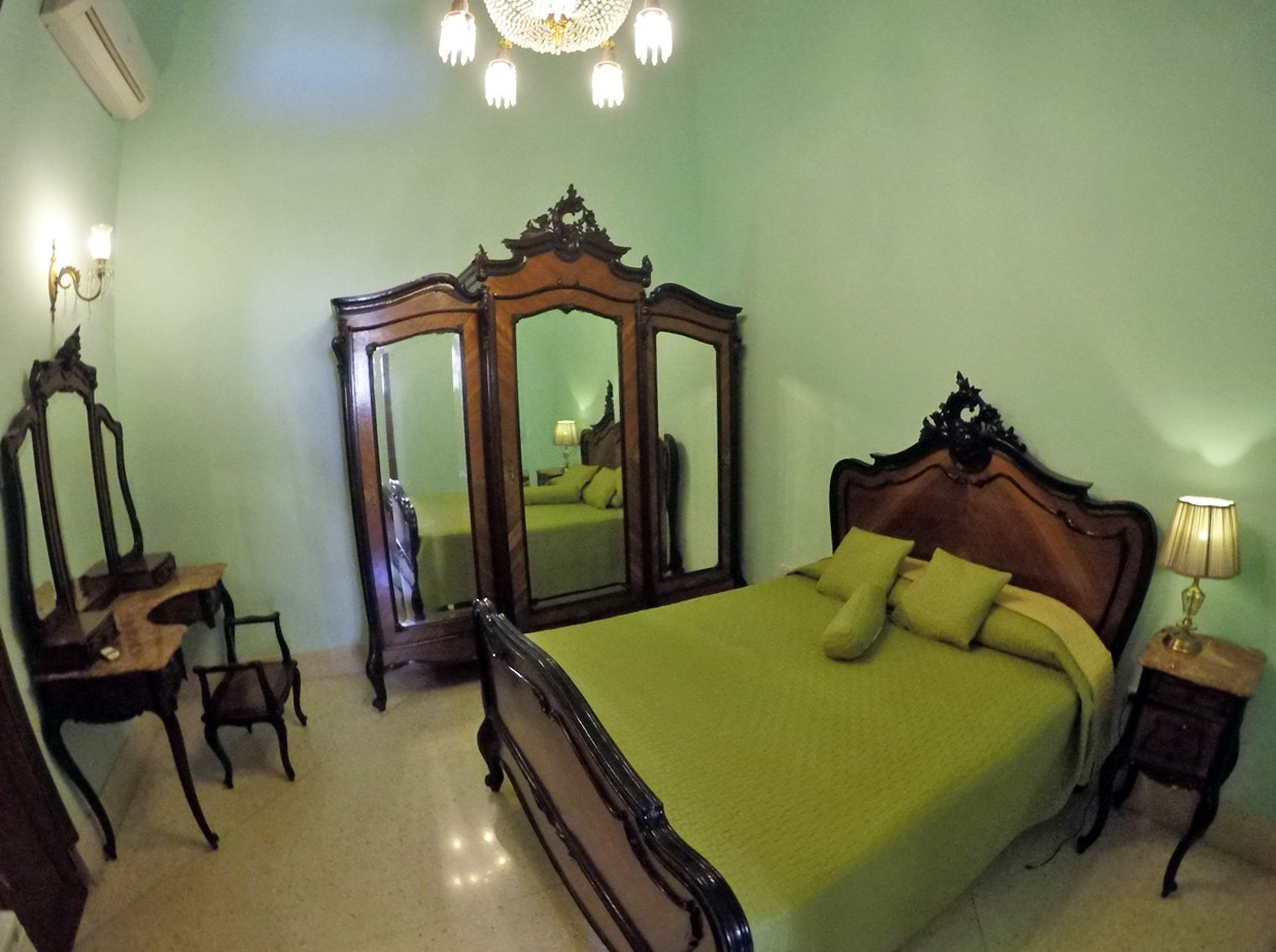 A private guesthouse room in Havana with some fancy furniture.